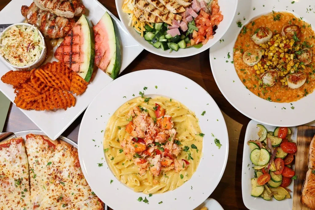 Overhead view of a table with diverse restaurant dishes.