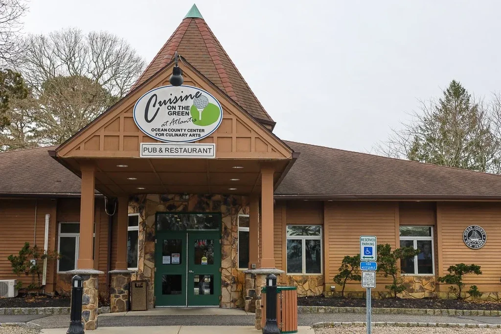 Multi-peaked "Cuisine on the Green" building exterior with stone accents.