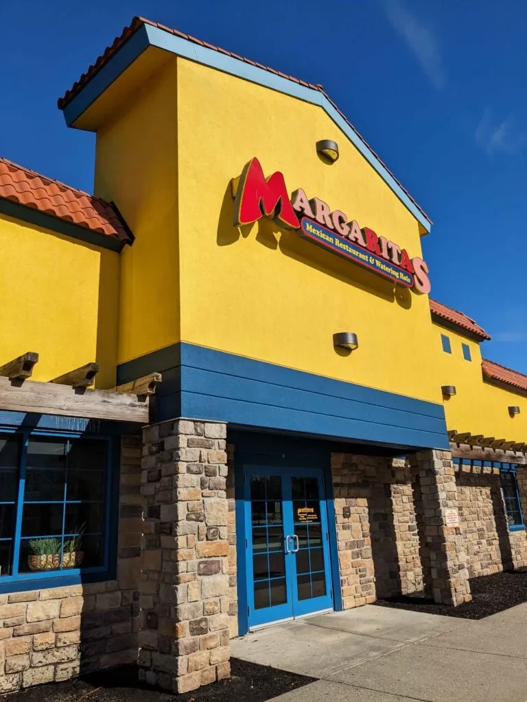 Bright yellow Margaritas Mexican Restaurant exterior with blue trim and terracotta roof.