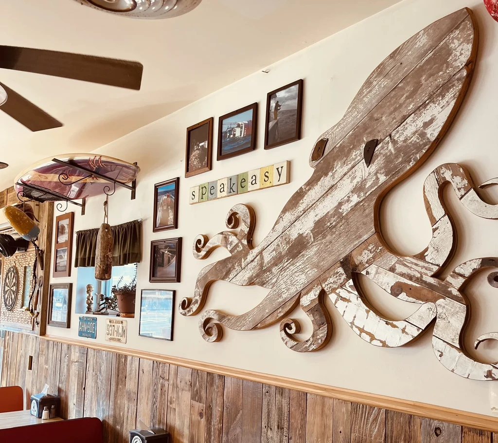 Large wooden octopus art, speakeasy sign, and rustic nautical decor.