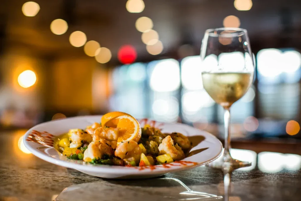 Close-up: Pan-seared seafood, fruit salsa, and white wine.