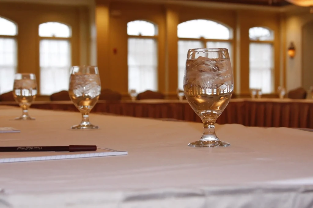 Elegant room with water glasses, ice, and Union Bluff Hotel pen.