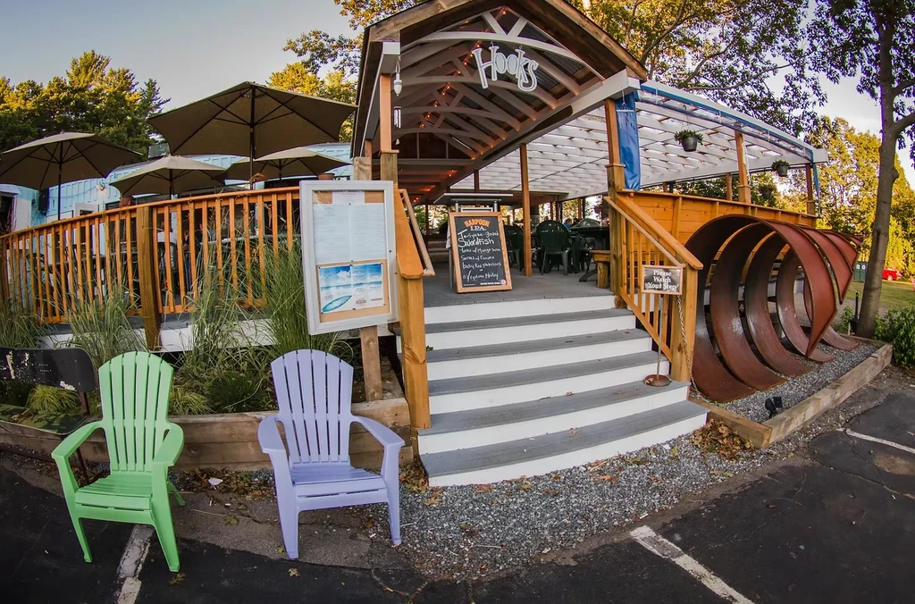 Hooks restaurant exterior with wooden deck, shaded patio, and Adirondack chairs.