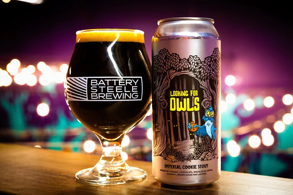 Dark beer glass with "Battery Steele" logo and "Looking for Owls" can.