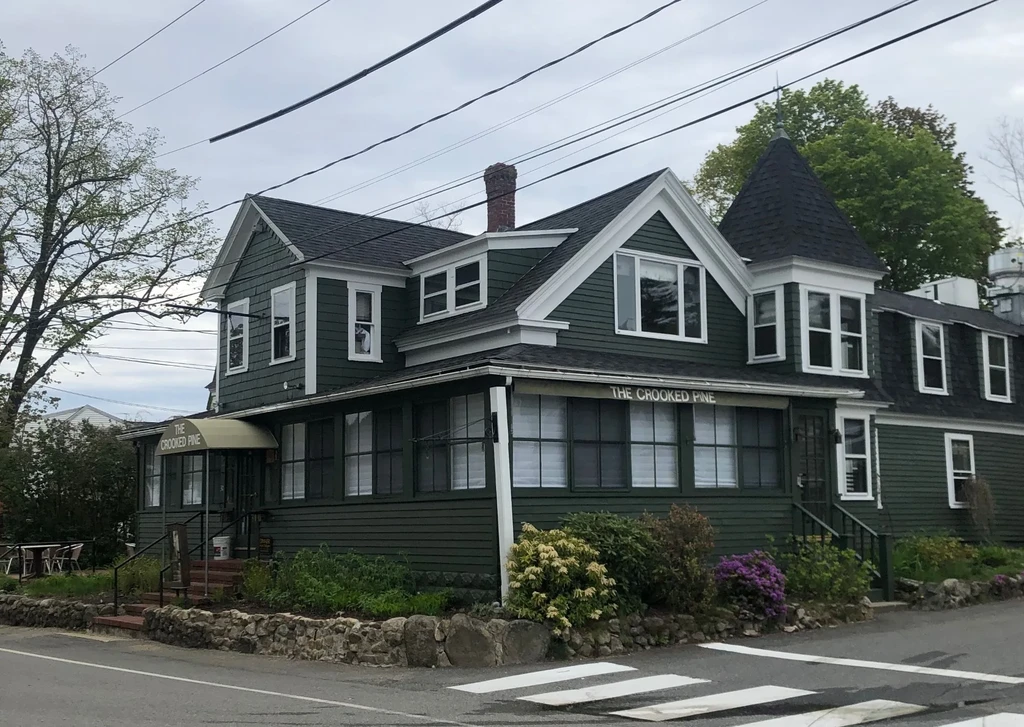 The Crooked Pine, a dark green historic building with a pointed turret.