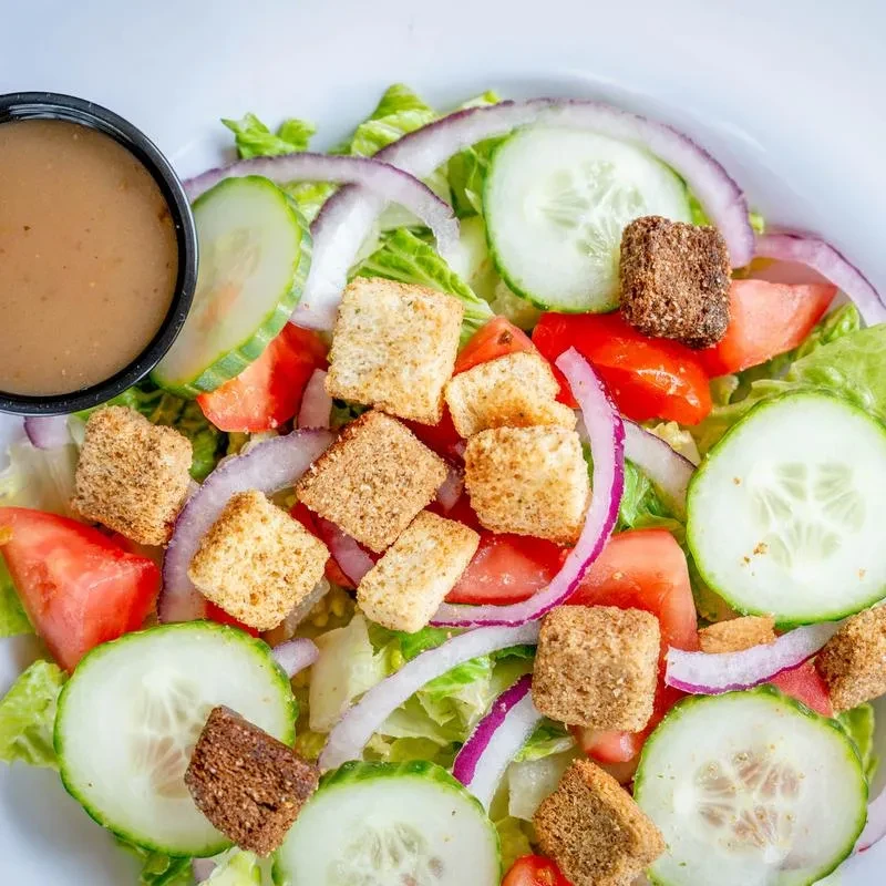 Fresh garden salad with lettuce, tomato, cucumber, croutons, and dressing.