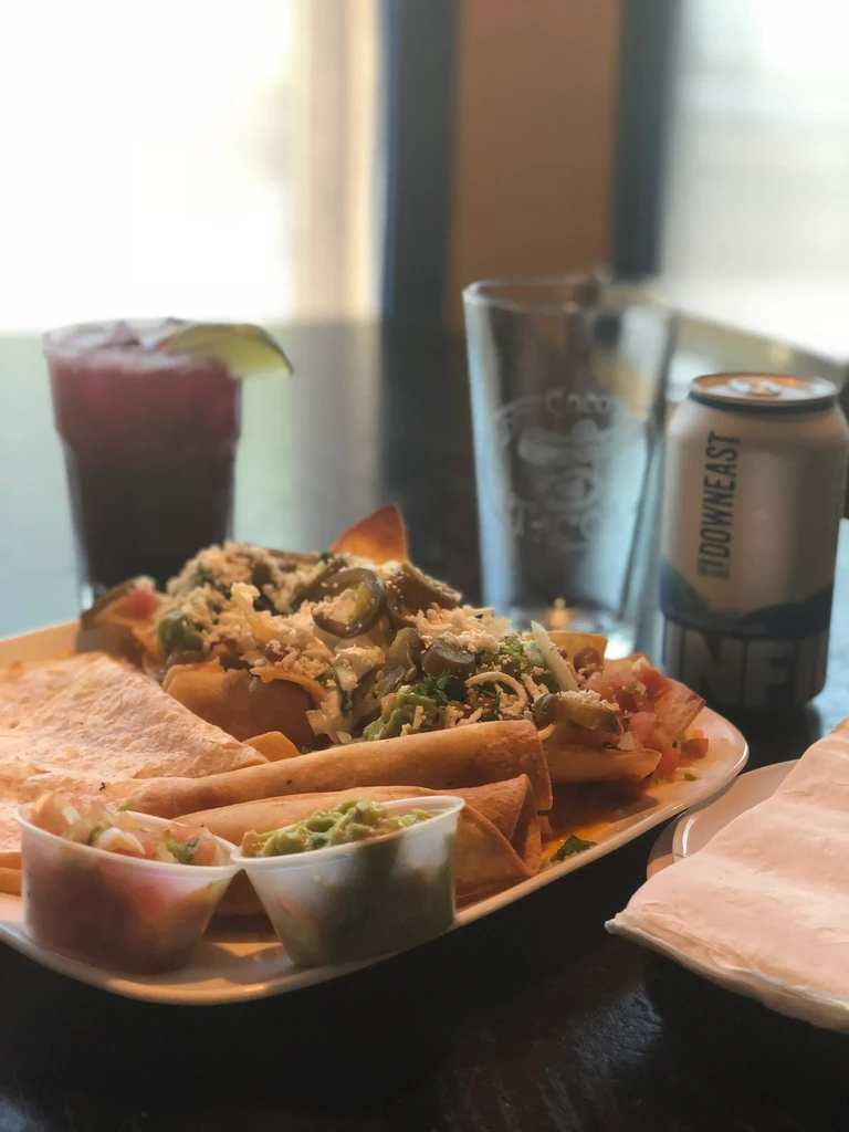 Platter of nachos, rolled tacos, quesadilla wedges with salsa and guacamole.