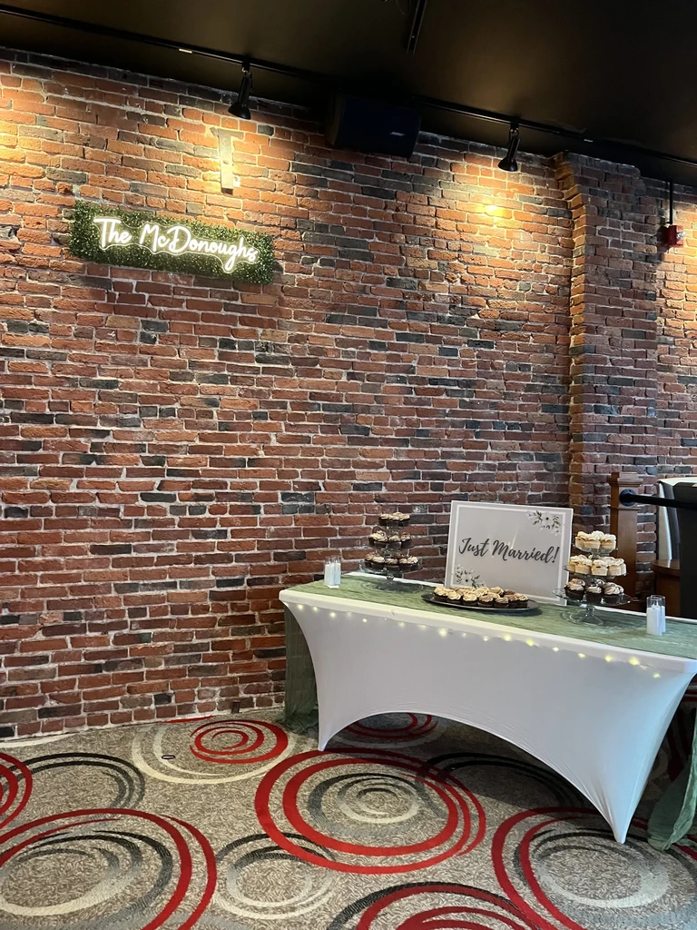A 'Just Married' dessert table and 'The McDonoughs' neon sign.