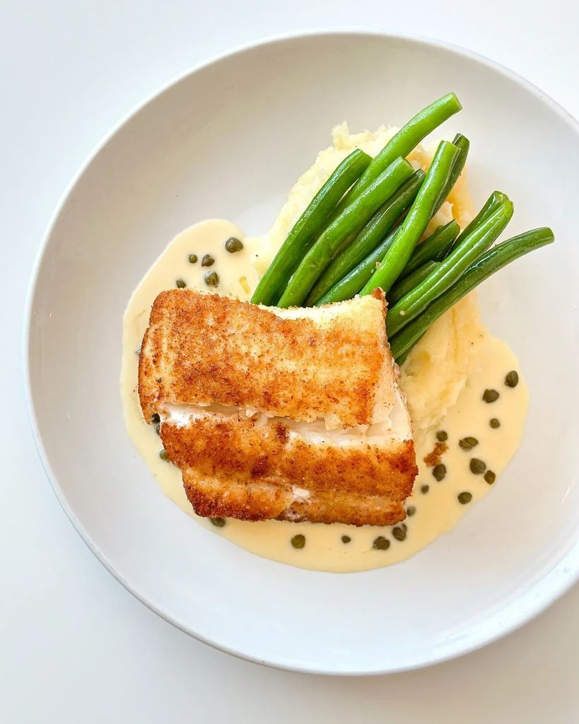 Breaded fish, mashed potatoes, green beans, with caper sauce.