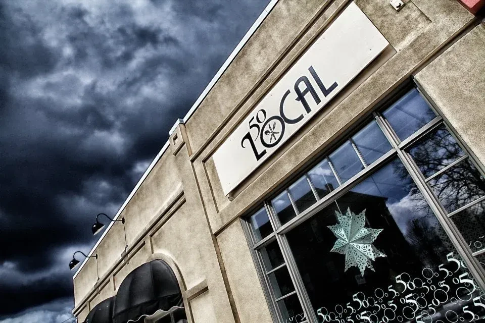 L 50 LOCAL restaurant exterior with stucco facade under a dark sky.