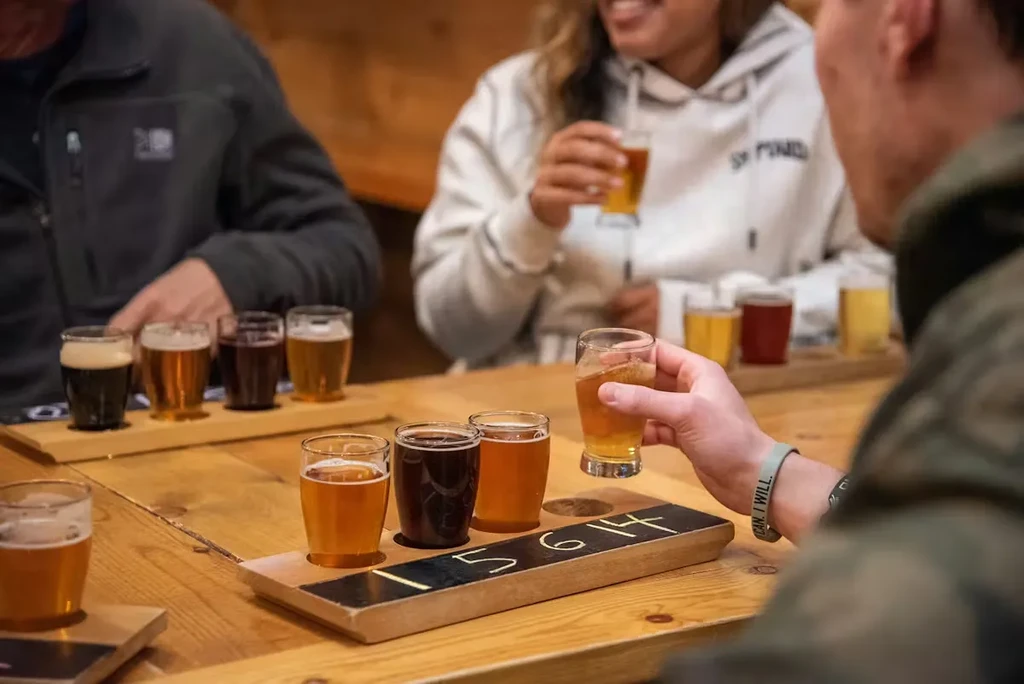 Hand holds a craft beer glass from a tasting flight.