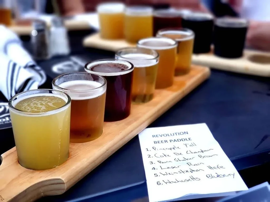 Wooden beer paddle featuring six distinct beers and a handwritten menu.