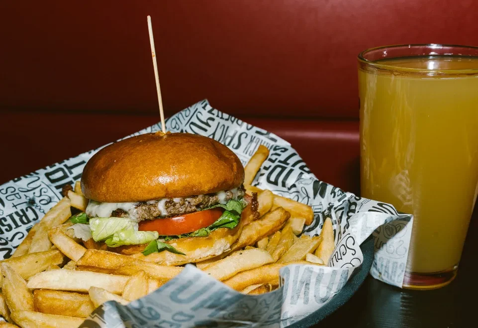 Classic burger with melted cheese, golden fries, and a drink.