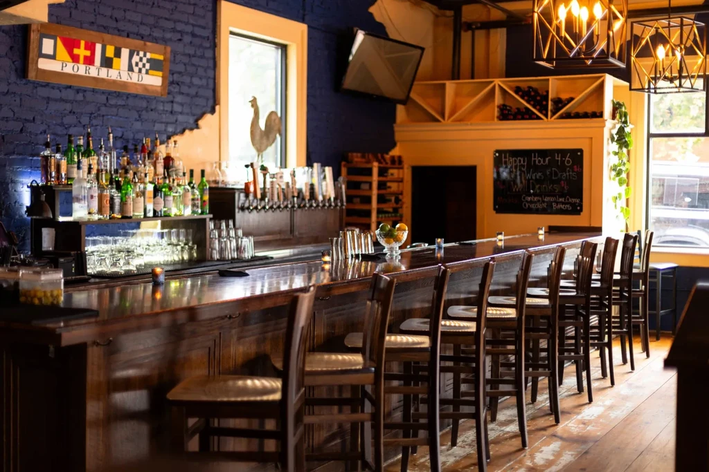 Empty wooden bar counter with liquor, beer taps, and a Portland sign.