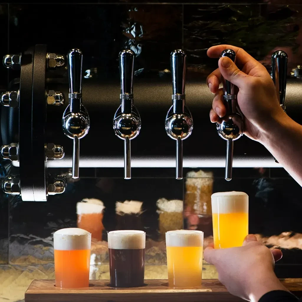 Close-up of beer tasting flight, hand pulling a tap.