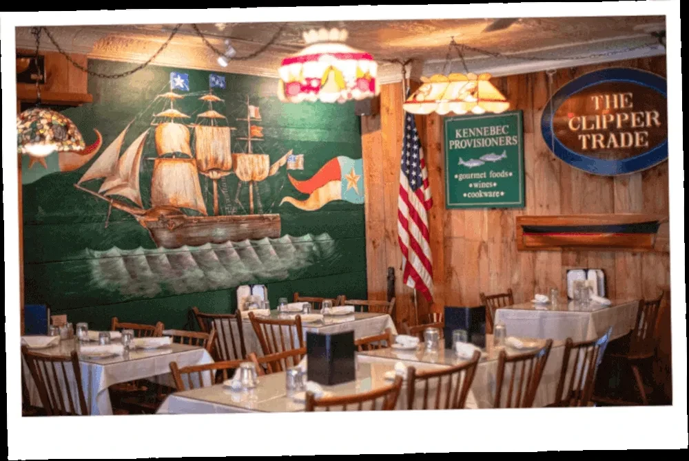 Nautical restaurant interior with ship mural, American flag, and dining tables.