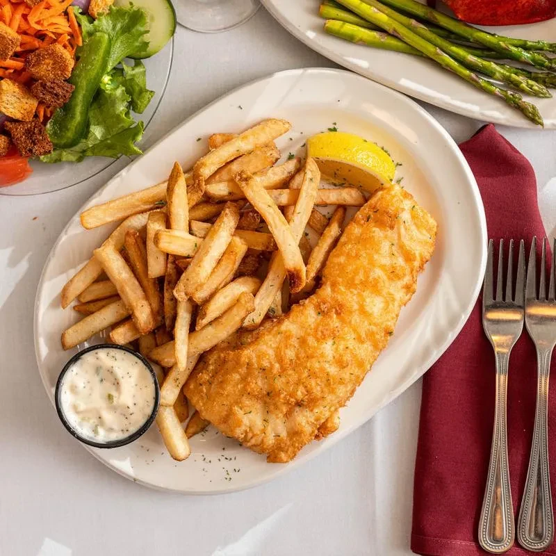Fish and chips, salad, with lobster and asparagus in background.