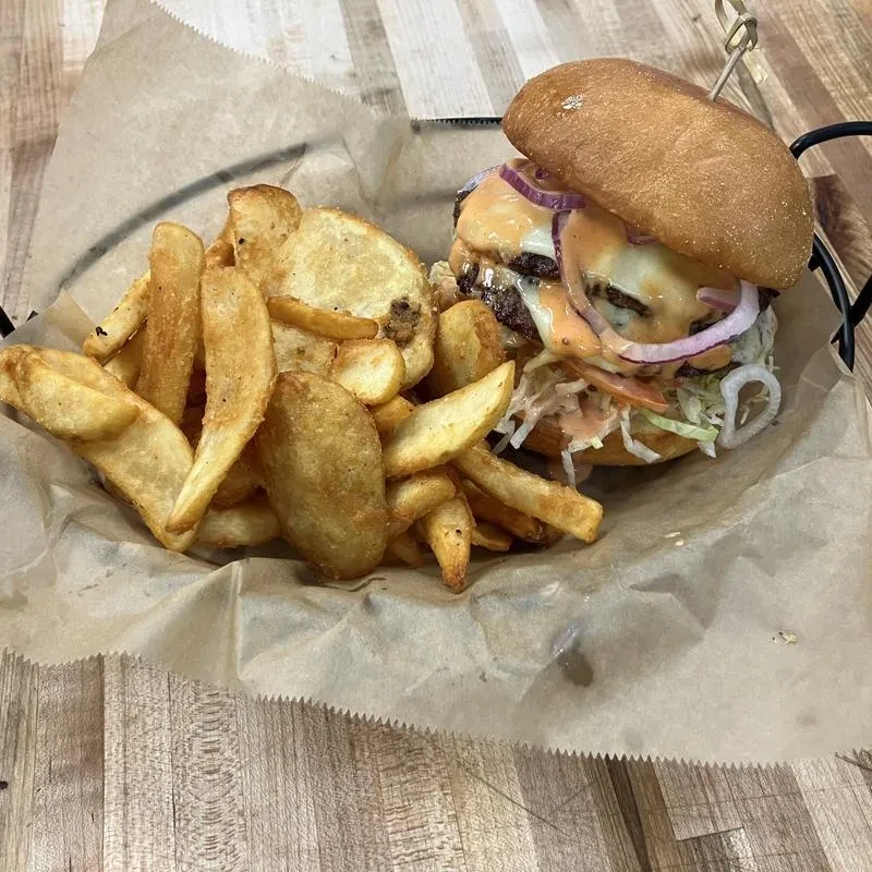 Double-patty burger with melted cheese and potato wedge fries.