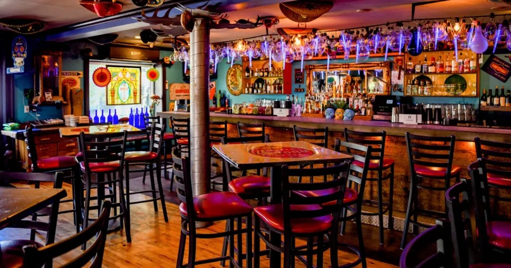 Colorfully decorated Mexican-themed restaurant interior with bar and unique lighting.