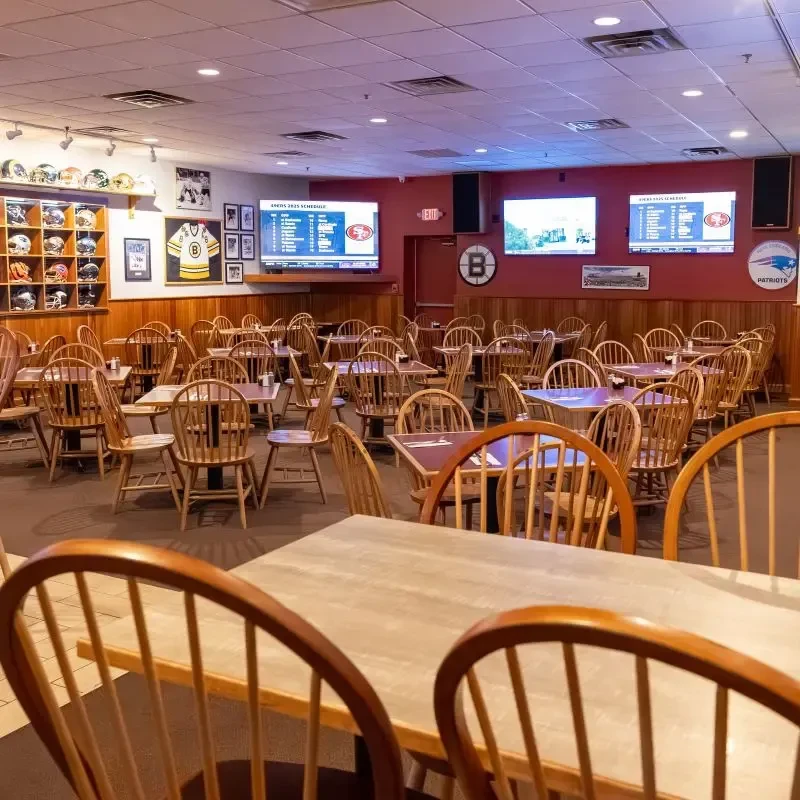 Empty sports-themed restaurant dining area with TVs and memorabilia.