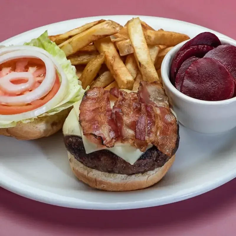 Open-faced bacon cheeseburger, french fries, and beets on a plate.