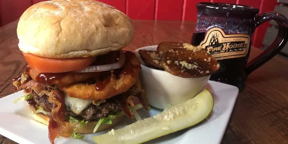 Hamburger with cheese, bacon, wedges, and pickle at Fire House.