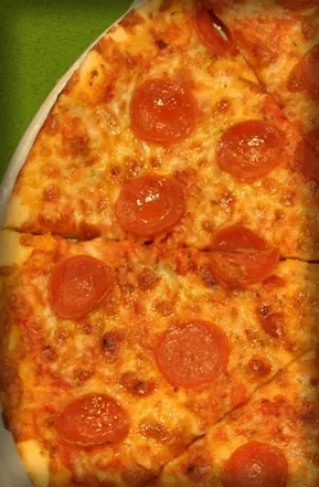 Close-up of pepperoni pizza slices with bubbly cheese and green background.