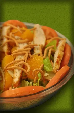 Colorful salad with grilled chicken, mandarin oranges, greens, and crispy noodles.