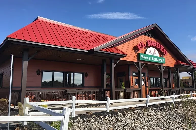 Mexican restaurant "El Rodeo" with red roof and white split-rail fence.