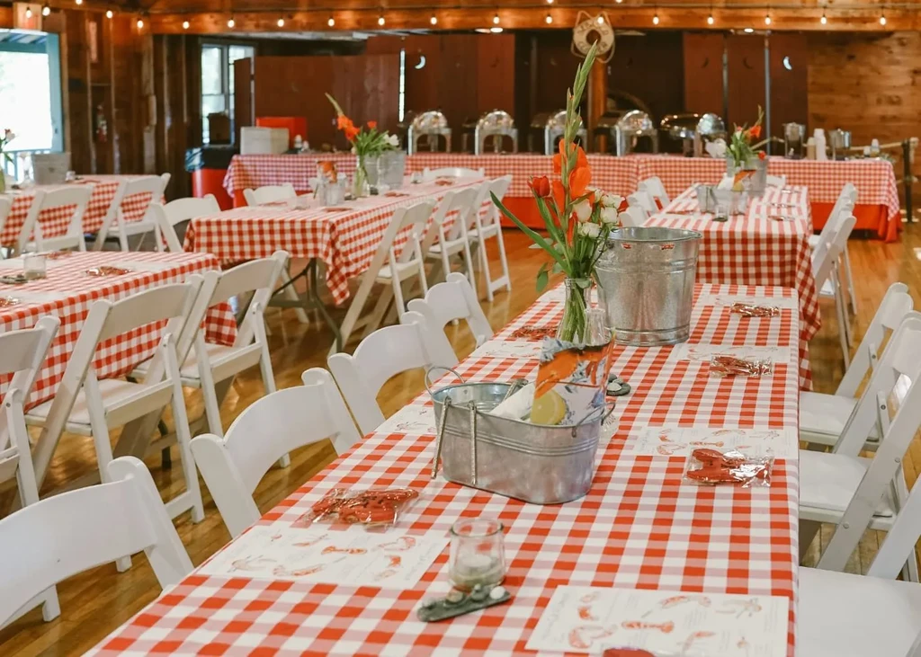 Spacious event hall with red checkered tables and a seafood buffet.