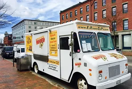 White 'El Rodeo SoPo' Mexican food truck on urban brick sidewalk.