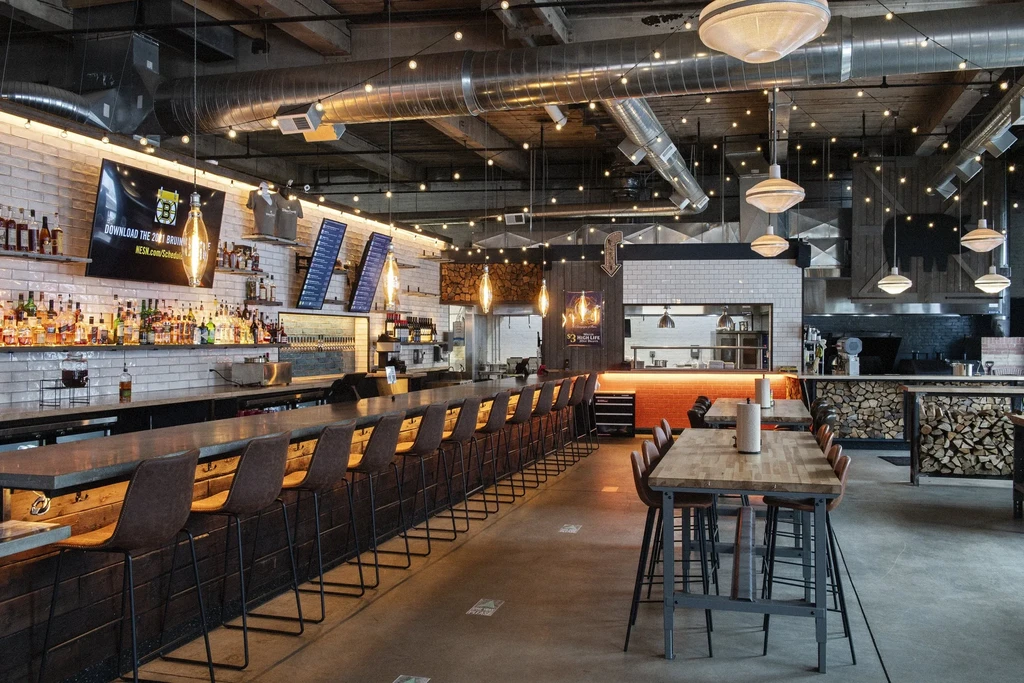 Empty industrial-chic bar and restaurant with an open kitchen.