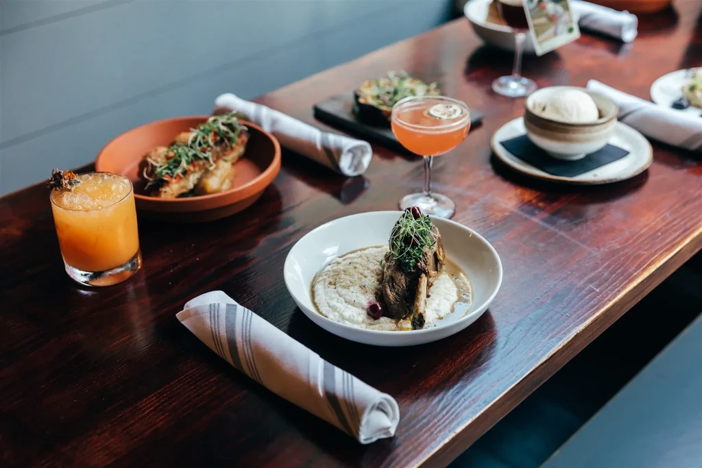 Restaurant table showcasing meticulously plated food dishes and drinks.