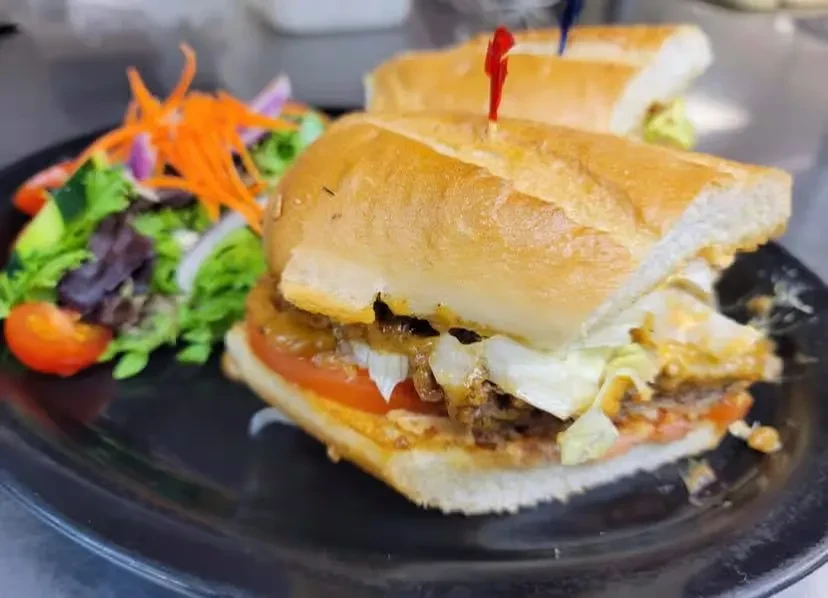Two large meat and cheese subs with a fresh side salad.