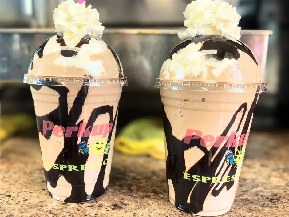 Two Perkup Espresso frozen drinks, chocolate-swirled with whipped cream.
