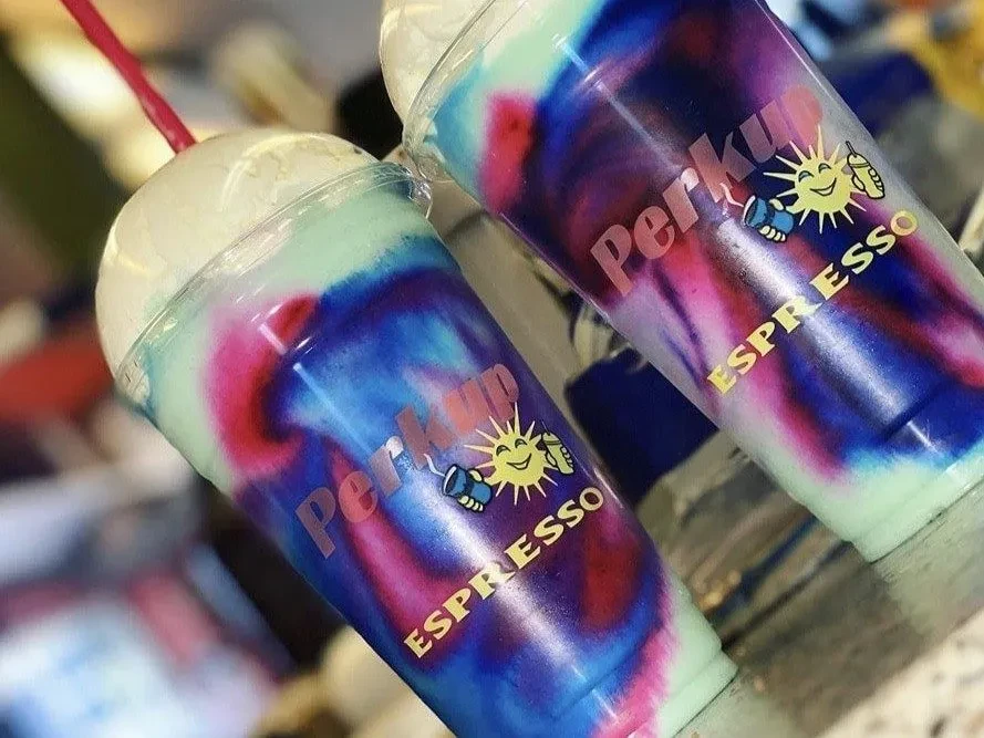 Two colorful layered Perkup Espresso drinks with whipped cream.