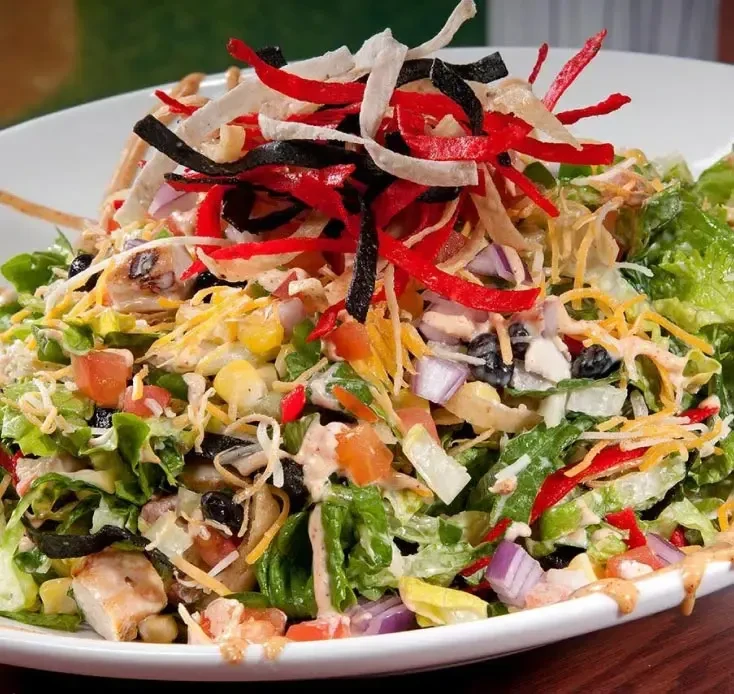 Colorful Southwestern salad with grilled chicken, black beans, corn, and tortilla strips.