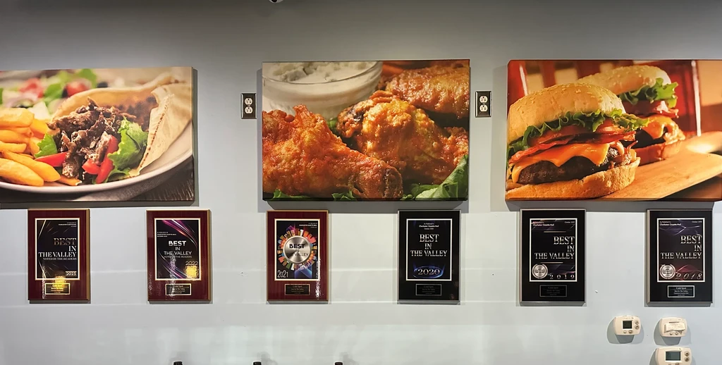 Restaurant wall displays food photos and six "Best in the Valley" awards.