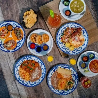 Top-down view of various Mexican dishes, drinks, and tortilla chips.