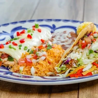 Plate of Mexican food: enchilada, taco, rice, refried beans.