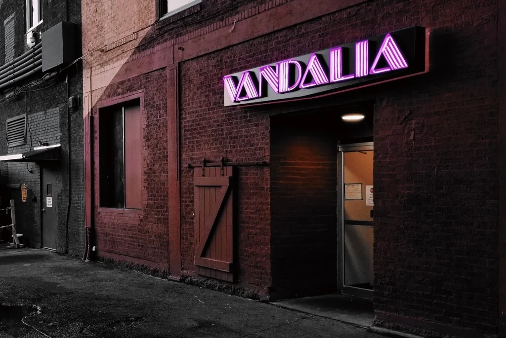 Selective-color brick building with glowing purple 'VANDALIA' neon sign.