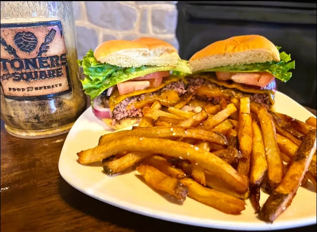 Cut double cheeseburger with fries and 'Stoners Square' bottle.