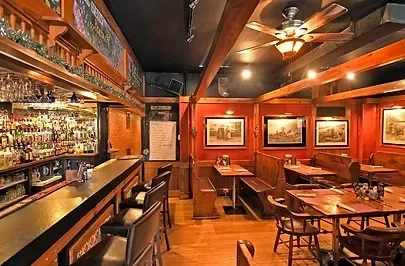 Empty rustic bar and dining area with dark wood and red walls.