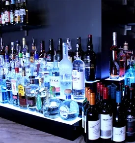 LED-lit bar displays numerous liquor and wine bottles on tiered shelves.