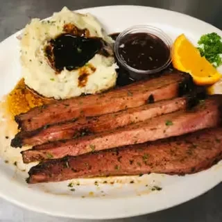 Roast beef, mashed potatoes, and gravy on a white oval plate.