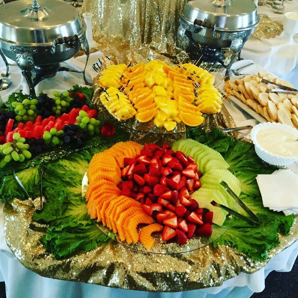 A vibrant tiered fruit platter on an elegant, catered buffet table.