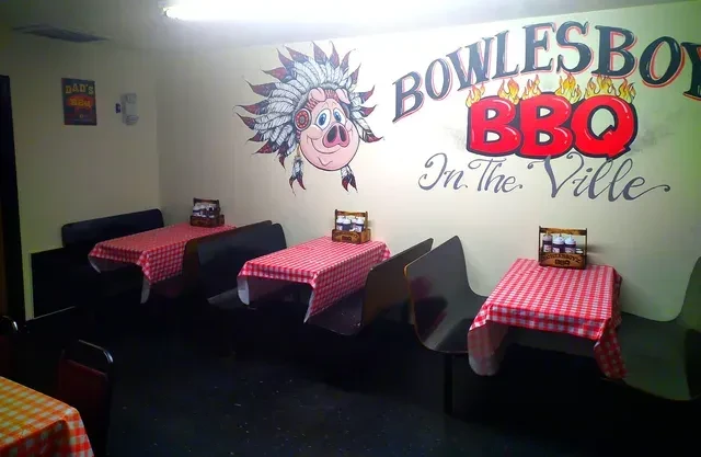 Casual restaurant interior with checkered booths and a pig BBQ mural.