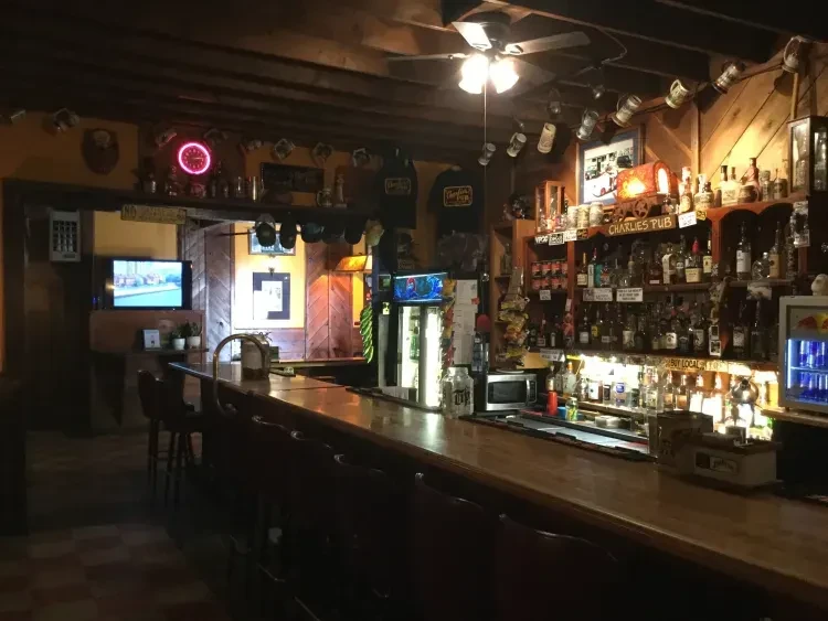 Interior of Charlie's Pub with a long wooden bar and liquor.