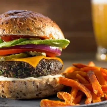 Close-up of a plant-based burger and sweet potato fries.