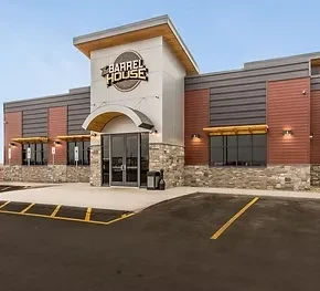 Exterior of modern Barrel House building with mixed facade and parking.